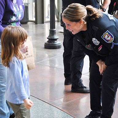 A Spokane Police Officer Talking to a Girl at a Coffee with a Cop Event