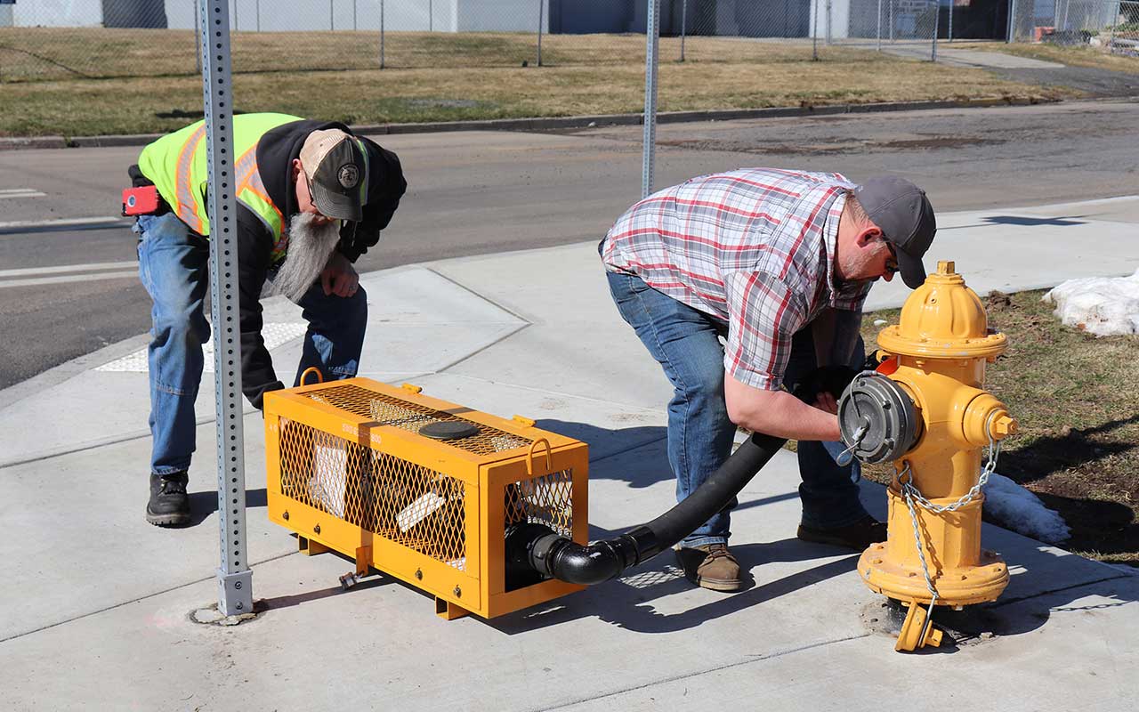 Staff set up backflow prevention cage